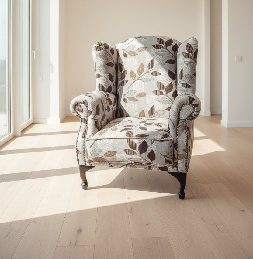 Decorative armchair with leaf pattern in a bright room with large windows.